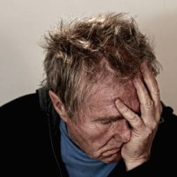 man holding his head in pain