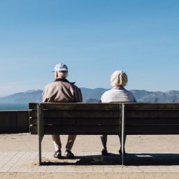 Two seniors sitting on bench overlooking valley