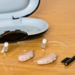 Close up of a pair of tiny modern hearing aid on bedside table