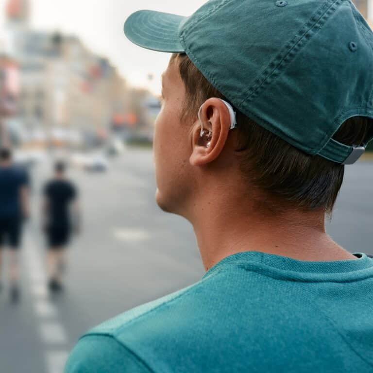 Man in a baseball hat wearing a hearing aid