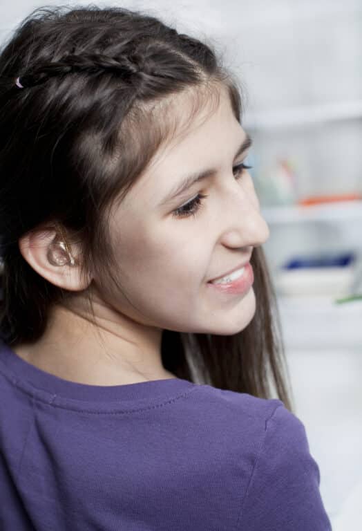 A person with hearing aids smiling. A person with hearing aids smiling.